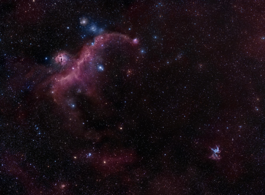 Links oben verläuft ein dunkelrosa leuchtender Nebelstrang, links daneben leuchtet ein kreisförmiger rosa Nebel, beide erinnern zusammen an eine Möwe. Rechts unten leuchtet ein winziger türkiser Nebel, den man bei genauer Betrachtung als Thors Helm erkennt.
