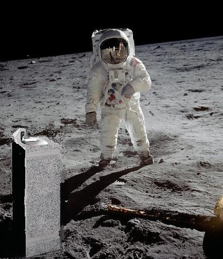 Vor einem Astronauten auf der Mondoberfläche steht links vorne im Bild ein Wasserspender auf einem quaderförmigen Betonblock. Dahinter breitet sich die graue, staubige Mondoberfläche bis zum Horizont aus.