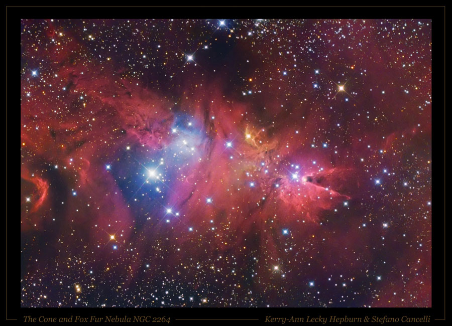 Im schwarz umrandeten Bild ist ein Nebel von Sternen umgeben. Der Großteil des Nebels leuchtet rot, in der Mitte sind einige Sterne mit blauem Hof, rechts ragt der dunkle Kegelnebel mit heller Spitze ins Bild.