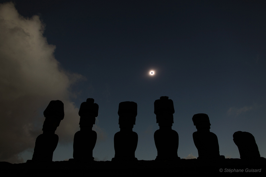 Pber sechs Silhouetten von Moai auf den Osterinseln leuchtet die Corona der Sonne. Man sieht sie, weil die Sonne vom Mond verdeckt wird.