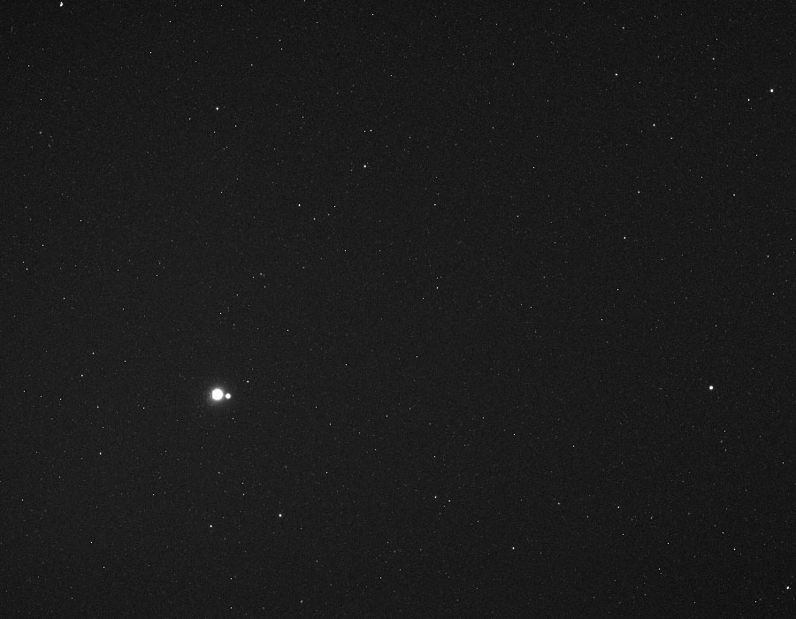 Zwei helle Lichtpunkte leuchten im Bild, es ist die Erde und ihr relativ großer Mond, wie die Raumsonde MESSENGER sie von Merkur aus sah.