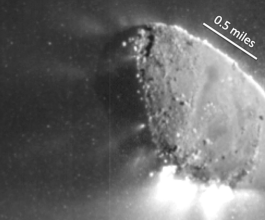 Im Bild ist ein verschwommen abgebildeter Gerällhaufen zu sehen, er wird von rechts beleuchtet, nach links und unten strömen helle Strahlen aus.