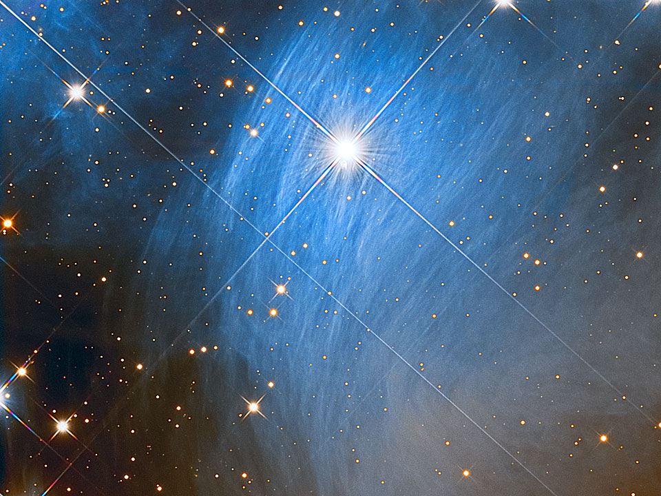 Oben in der Mitte strahlt ein heller Stern, hinter dem eine gefaserte blaue Wolke leuchtet. Im Bild sindeinige gezackte Sterne verteilt.