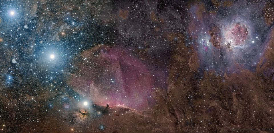 Das Panorama zeigt die Molekülwolke im Orion, rechts oben ist der Orionnebel, links unten der Flammennebel und der Pferdekopfnebel, von dort aus steigen die drei Gürtelsterne des Orion nach links oben diagonal auf. 