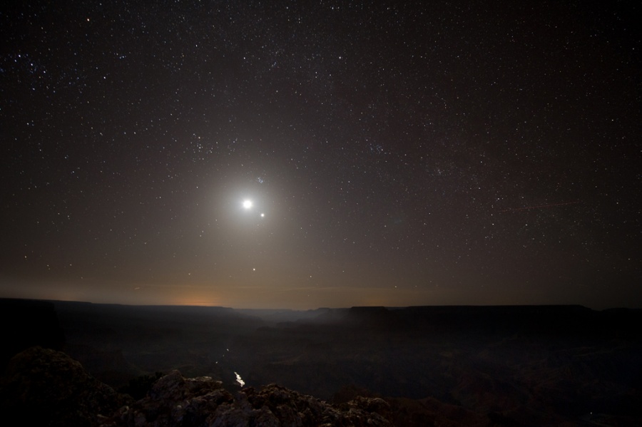 Am dunklen Nachthimmel leuchten über dem Horizont zwei Lichter, der Mond neben dem Planeten Venus.