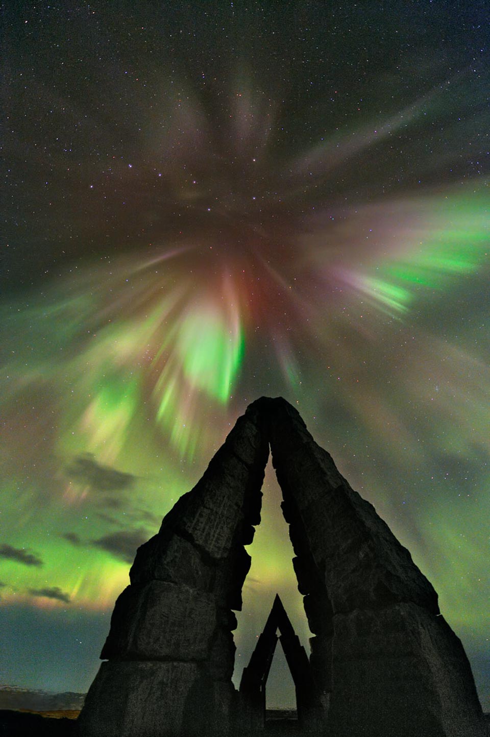 Über dem arktischen Henge Heimskautsgerði explodiert ein Polarlicht genau im Norden. Zwei Steinfirste sind so aufgestelt, dass ihre Firstlinien genau nach Norden zum Polarstern zeigen.