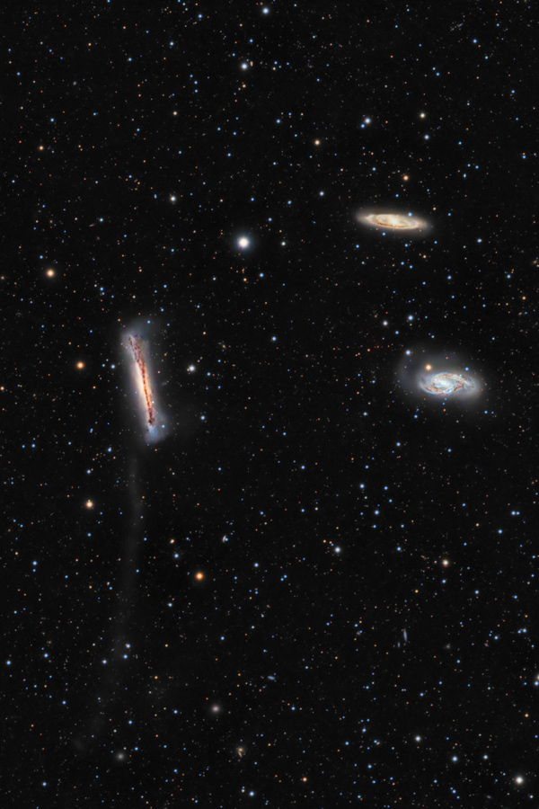 Im Bild sind drei markante Galaxien zwischen Sternen verteilt. Die linke Galaxie ist von der Seite zu sehen, sie wirkt fluffig und aufgebauscht. Die beiden Galaxien rechts haben eine ausgeprägte Spiralform.