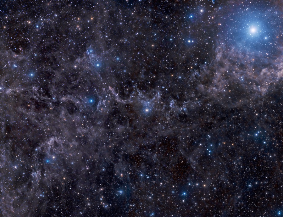 Links unter dem hellen blauen Stern Markab sind viele Staubwolken verteilt, dazwischen leuchten viele dicht verteilte Sterne und einige Galaxien.