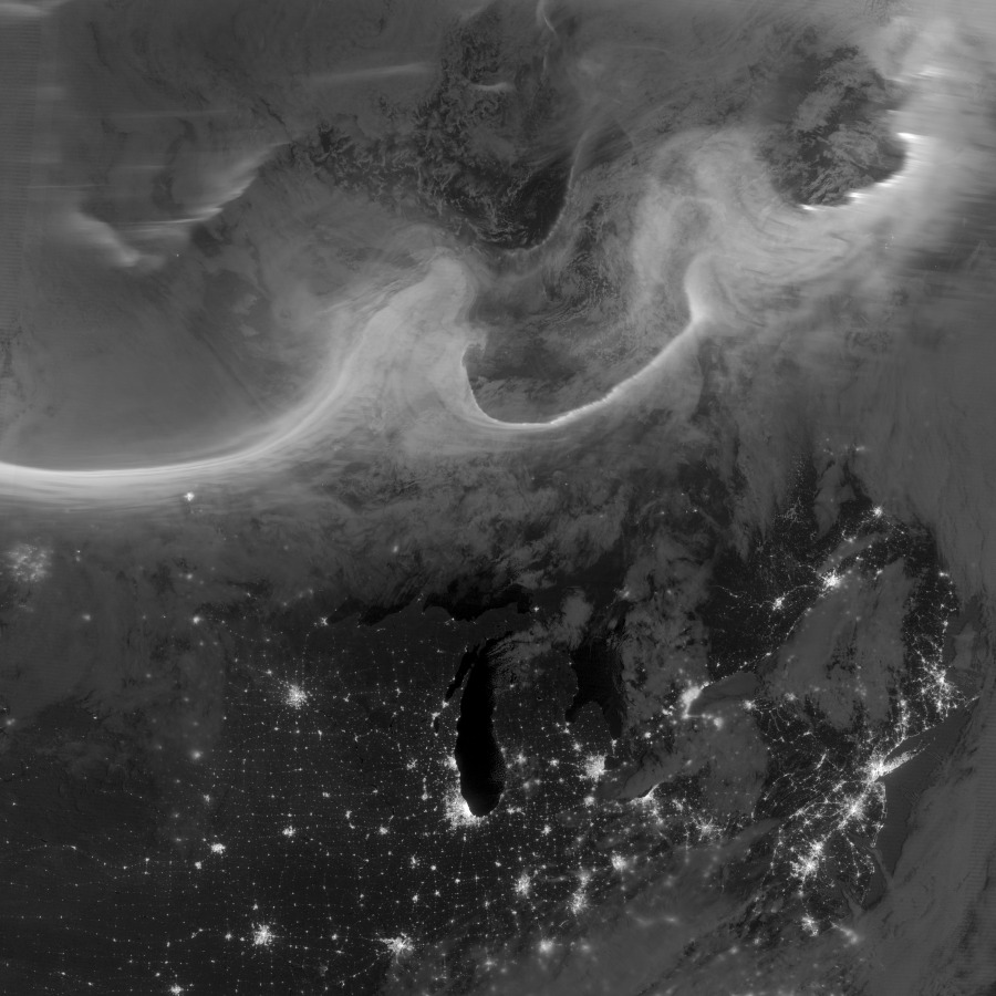 Über dem nächtlichen Kontinent Nordamerika leuchten helle Wellen, es sind Nordlichter, die weit nach Süden reichen.