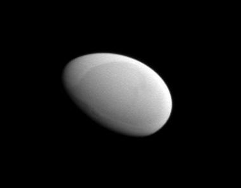 Der Saturnmond Methone ist nur drei Kilometer groß und wirkt so glatt wie ein Ei. Er hst jedoch eine dunklere Stelle.