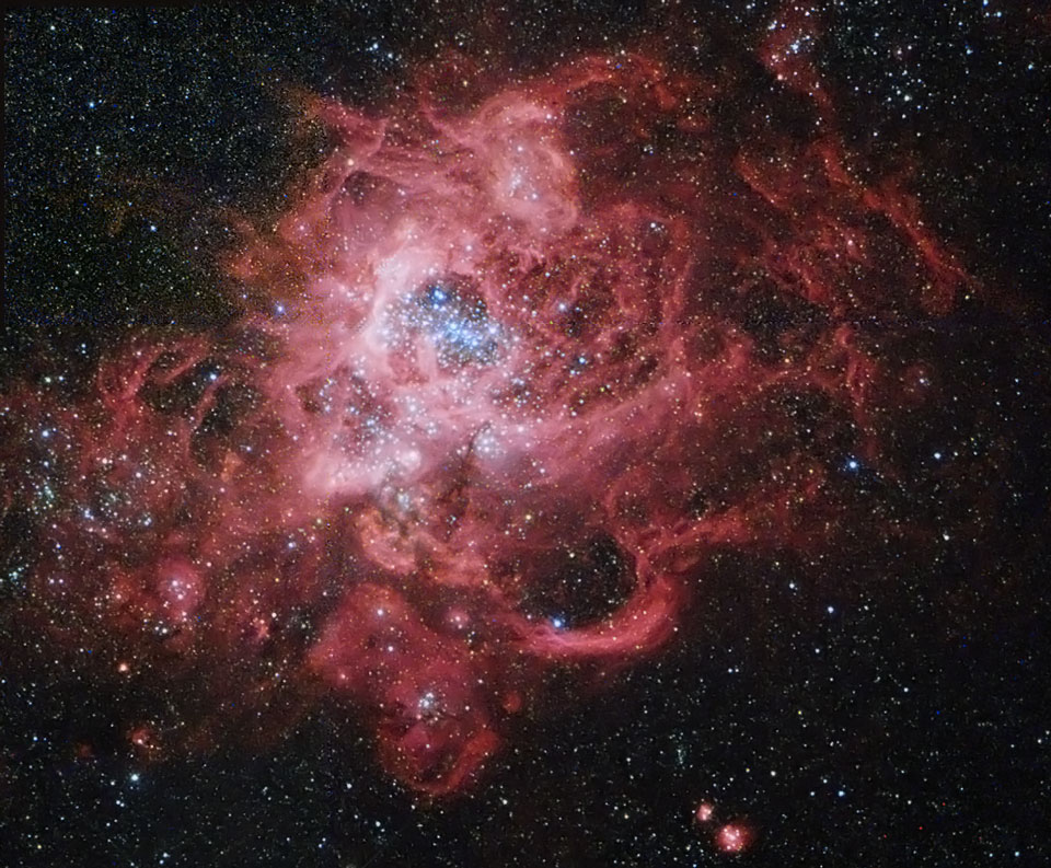 Diese rot leuchtende Gaswolke erinnert visuell an den Tarantelnebel. In seinem Inneren entstand ein ganzer Kugelsternhaufen, der in der MItte zu sehen ist, es ist NGC 604 in der Dreiecksgalaxie M33.