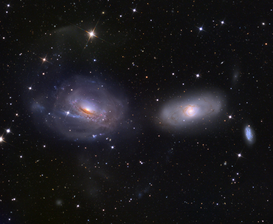 Mitten im Bild leuchten zwei schräge Galaxien, die an Augen erinnern.