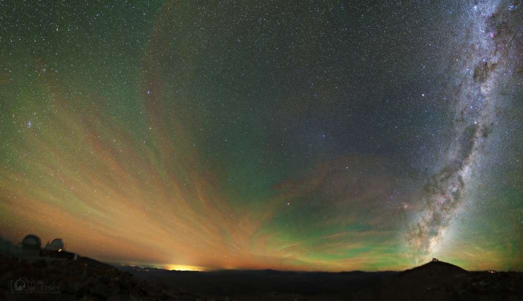 Grünliches Luftleuchten überzieht den Himmel über dem Las-Campanas-Observatorium in der chilenischen Atacamawüste. Rechts steigt die Milchstraße über den Magellan-Teleskopen auf, links stehen die Kuppeln des OGLE-Projekts und des du Pont-Teleskops.