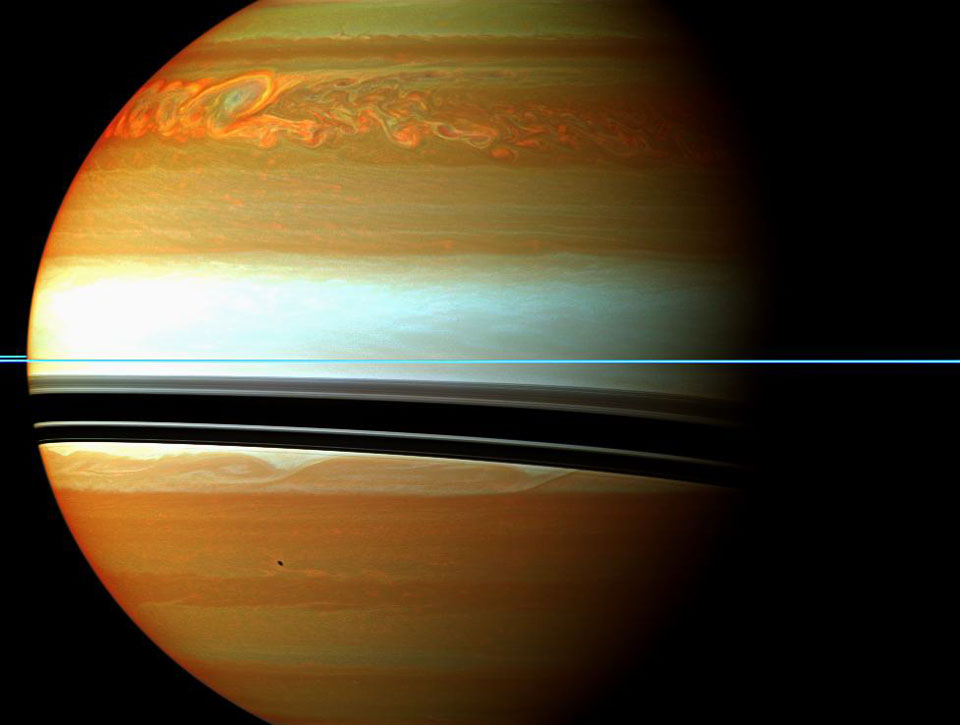 Die orangefarbene Saturnkugel mit weißer Mitte ist von links von der Sonne beleuchtet. Waagrecht verlaufen die Saturnringe durchs Bild, sie sind nur eine dünne blaue Linie. Die Schatten fallen nach unten auf Saturns Wolken. Oben tobt ein wirbelndes Sturmsystem.