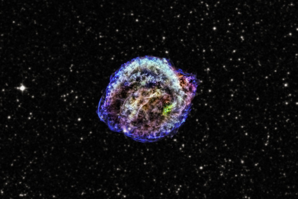 Mitten im Bild strahlt eine blau-türkis-violette Wolke. Sie entstand an der Stelle, wo Kepler vor etwa 400 Jahren eine Supernova beobachtete.