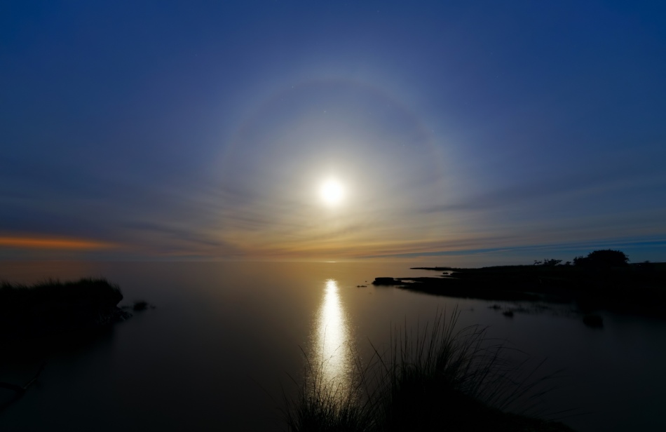 Über der Mündung des Rio de La Plata bei Buenos Aires geht der Mond auf. Er ist von einem 22-Grad-Halo umgeben.