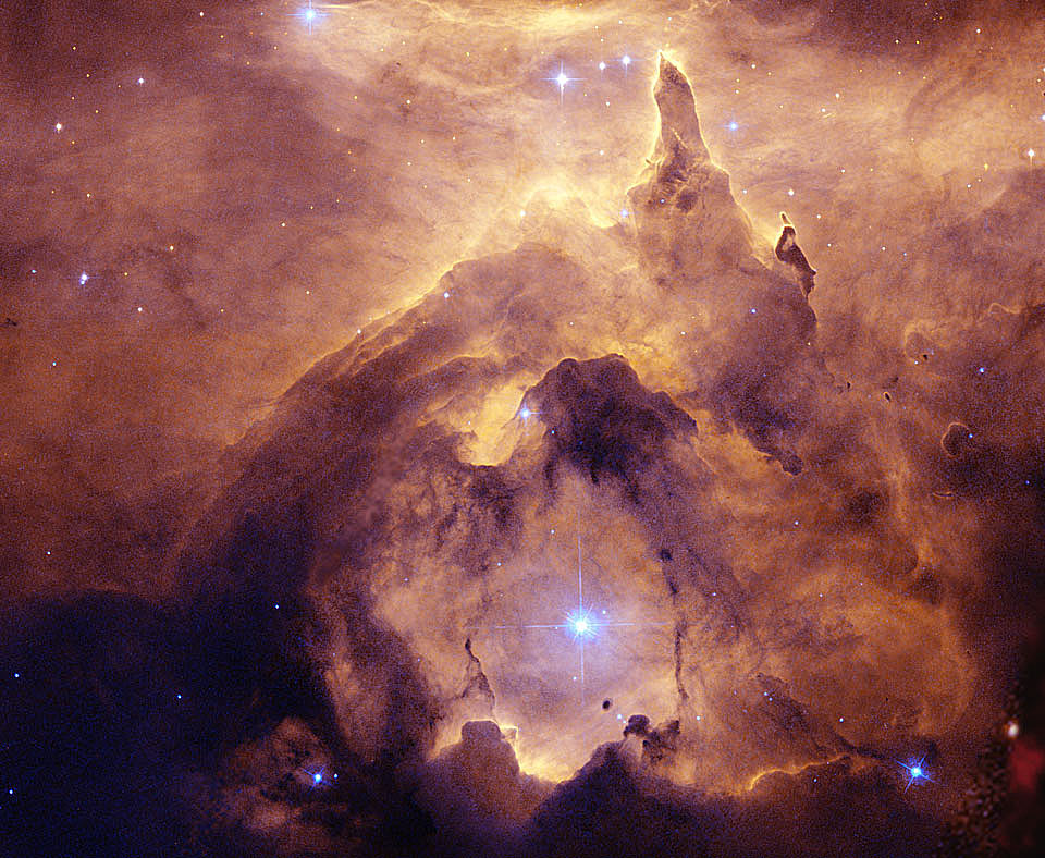 Ein heller blauer Stern ist von einer Höhle oder Kathedrale aus Staubwolken umgeben, der Nebel im Hintergrund leuchtet orangebraun.