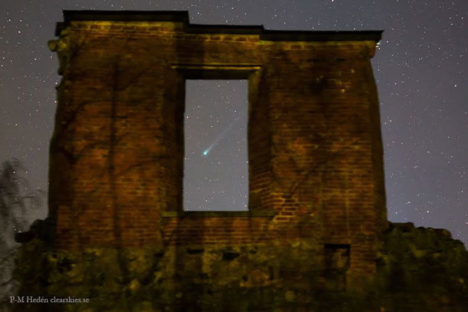 Durch eine Öffnung in der Ruine des schwedischen Schlosses Mörby sieht man den Kometen Lovejoy mit grüner Koma und langem Schweif.