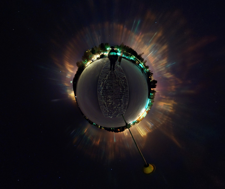 Ein 360-Grad-Panorama wurde zu einer Projektion gekrümmt, die wie ein kleiner Planet wirkt. Am Rand des Planeten leuchten gelbliche und grüne Lichter, nach außen sind rund um den Planeten senkrechte Lichtsäulen angeordnet.