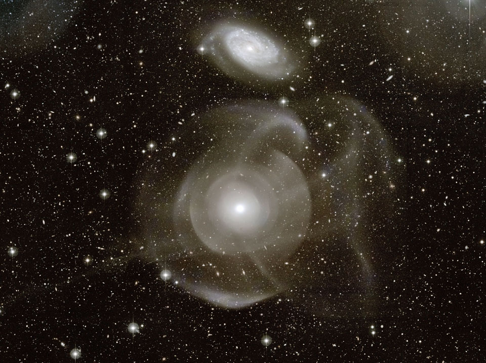 Die beiden Galaxien im Bild sind von komplexen Höfen umgeben, die wahrscheinlich ein Hinweis auf Gezeiten bei einer engen Begegnung sind.