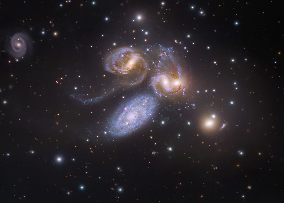 Mitten im Bild sind die fünf Galaxien von Stephans Quintett. Die bläuliche Galaxie in der Mitte gehört nicht zur Gruppe. Links oben ist eine kleinere Spiralgalaxie, die gleich weit entfernt ist wie vier Galaxien im Quintett.