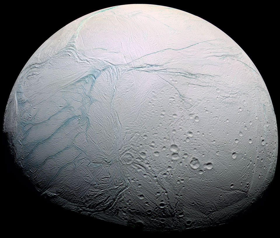 Der Saturnmond Enceladus ist hier zu etwa drei Vierteln beleuchtet. Auf seiner hellen Oberfläche sind nur rechts unten Krater zu sehen, sie sind nicht besonders groß oder zahlreich. Auf der ganzen Oberfläche verlaufen hellblaue Rillen, sogenannte Tigerstreifen. Besonders auffällig sind diese links.