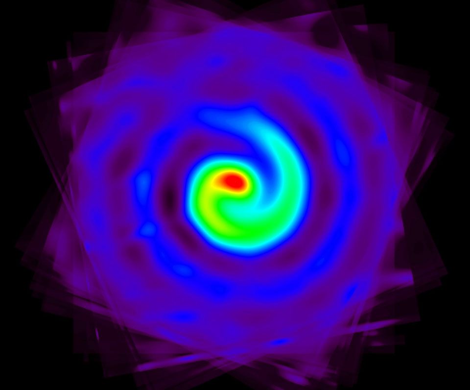Das Bild wirkt abstrakt. Es zeigt eine wirbelnde Spirale, die innen von Rot nach Gelb, Grün, Cyan, Königsblau und Purpur verläuft. An den äußeren Rändern wirkt das Muster wie ein wirbelndes Windrad.