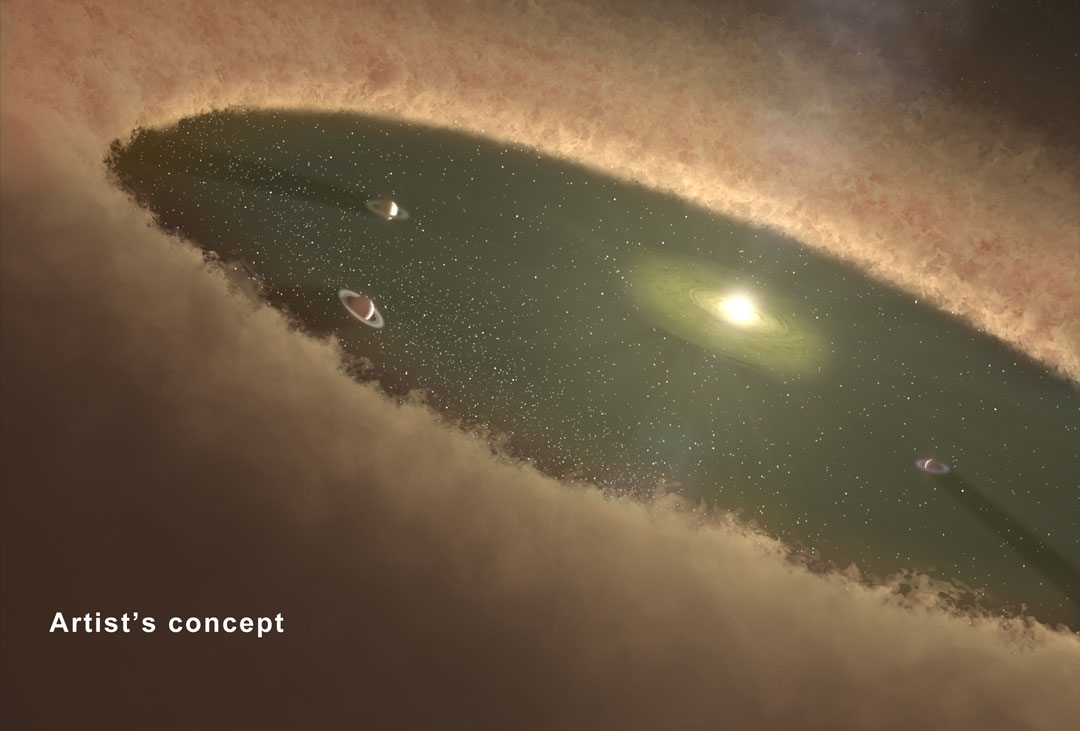 Eine Staubscheibe ist innen ein riesiges dunkelgrünes Loch. In der Mitte ist ein heller Stern von Staub umgeben, außen herum kreisen Planeten mit gewaltigen Ringsystemen.
