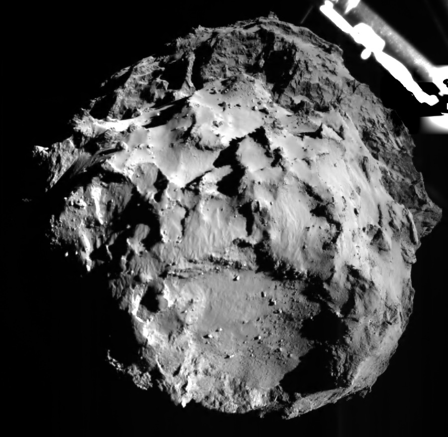 Mitten im Bild ist der drei Kilometer entfernte Kern des Kometen Tschurjumow-Gerassimenko. Links oben ist ein Teil der Landesonde Philae. Die Raumsonde nähert sich ohne Antrieb und Lenkung dem schuppigen Kometen.