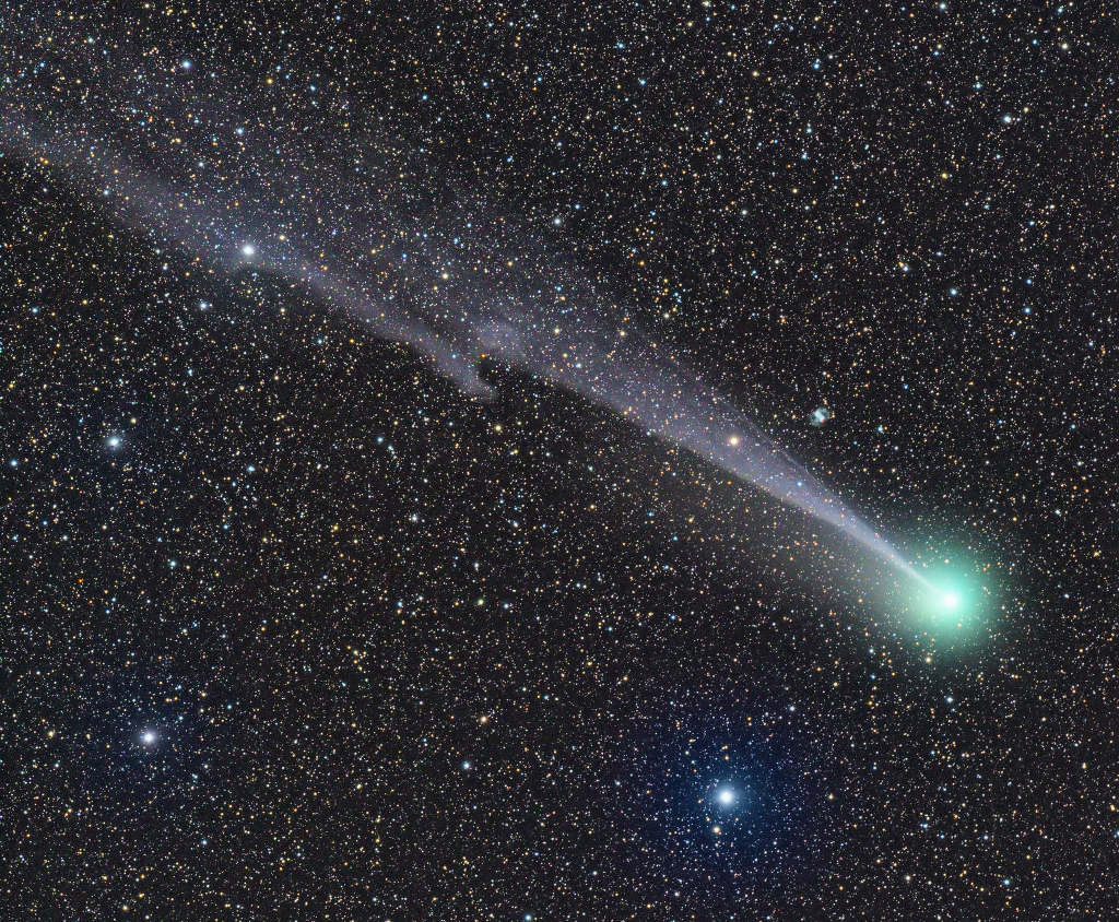 Sterne sind im Hintergrund dicht gedrängt, sie sprenkeln das ganze Bild. Rechts unten leuchten die grüne Koma des Kometen Lovejoy (C/2014 Q2) und der sehr blaue Stern Phi Persei. Knapp über dem Schweif ist der winzige planetarische Nebel M76 zu sehen.