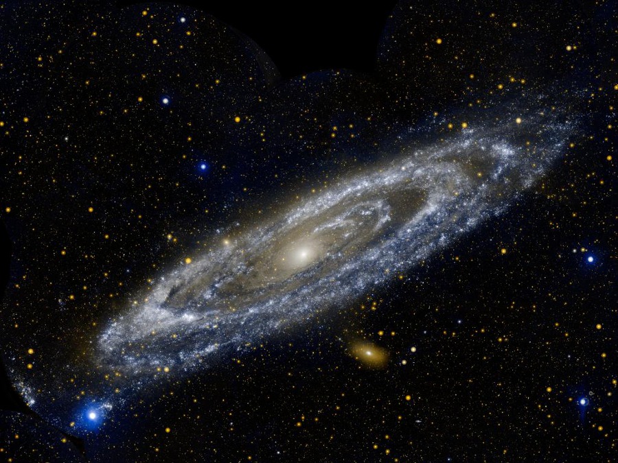 Die Andromedagalaxie ist in Ultraviolettlicht schräg abgebildet und wirkt verfremdet. Die Spiralarme treten stärker als sonst hervor.