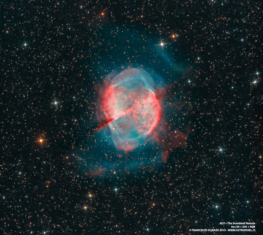 Der Hantelnebel (M27) im Sternbild Füchslein ist einer der markantesten planetarischen Nebel am Himmel. Der Emissionsnebel ist hier in rötlichen und graublauen Farben dargestellt. Der Hintergrund ist von vielen feinen Sternen gesprenkelt. Dazwischen leuchten wenige hellere Sterne.