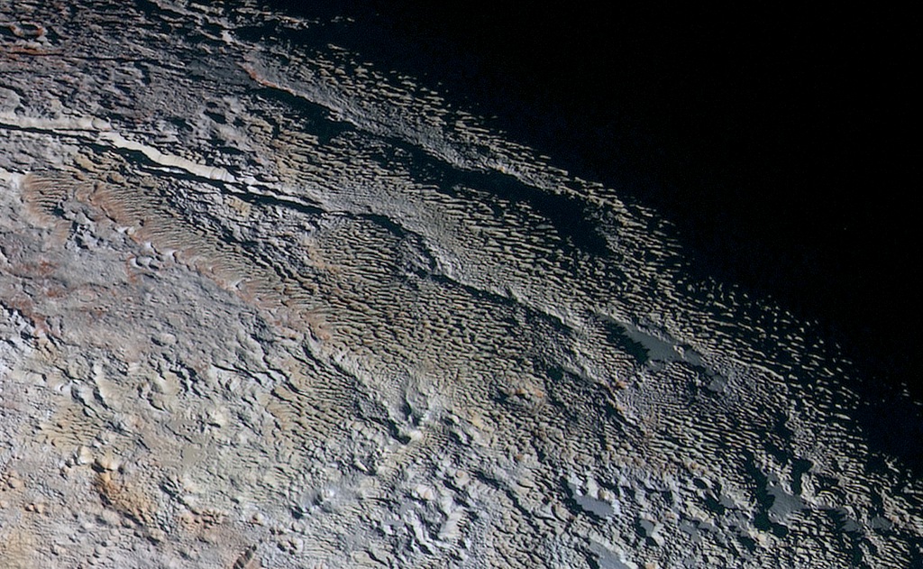 Die Oberfläche auf Pluto, die hier abgebildet ist, liegt nahe der Schattengrenze zur Nacht. Sie wirkt schuppig wie Schlangenhaut.