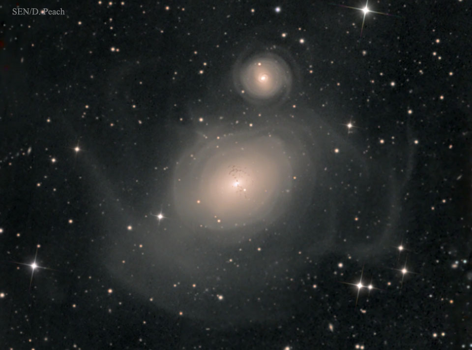 In der Mitte ist die elliptische Galaxie NGC 1316. Sie ist von schalenförmigen Hüllen umgeben. Diese sind ein Hinweis auf eine enge Begegnung mit der kleineren Galaxie NGC 1317 darüber.