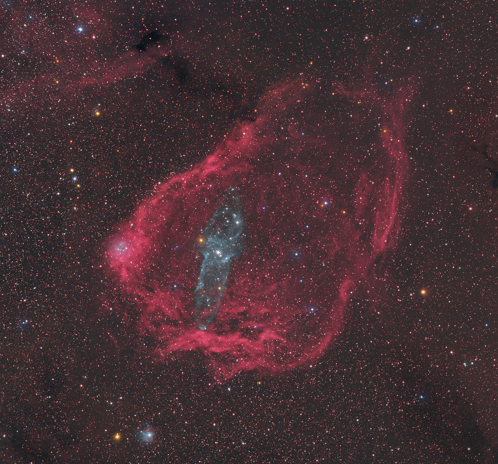 Der blau leuchtende Tintenfischnebel Ou4 ist von einer rötlich leuchtenden Hülle umgeben. Beide Nebel liegen im Sternbild Kepheus, vielleicht sind sie sogar physikalisch miteinander verbunden.
