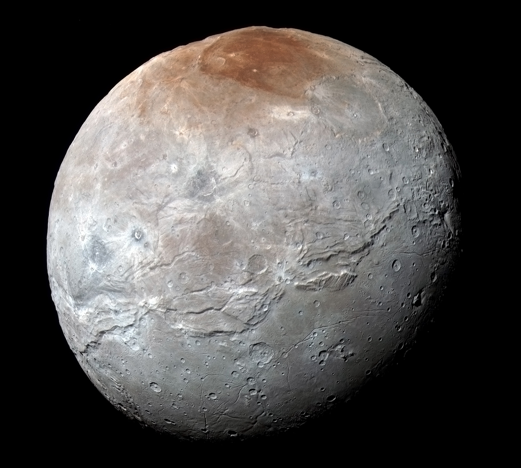Diese Seite des Mondes Charon zeigt immer zu Pluto. Oben am Pol ist eine rotbraune Verfärbung, sie heißt informell Mordor Macula. Um den ganzen Mond verläuft nahe dem Äquator ein Gürtel aus Rissen und Schluchten.