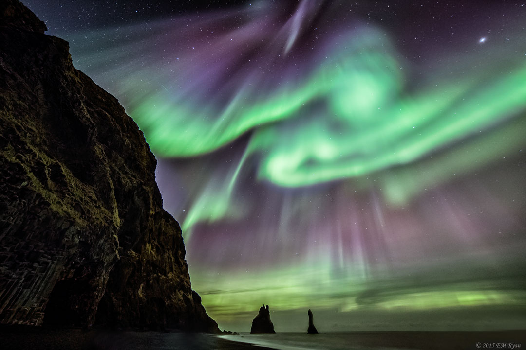 Polarlicht, Jupiter und der Sternenhimmel leuchten über einer isländischen Küstenlandschaft.
