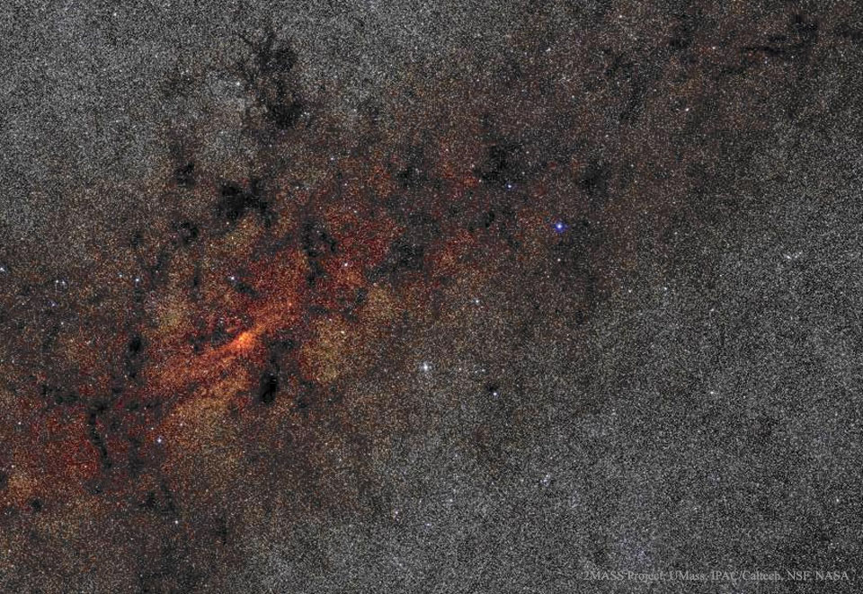 Der dichte Sternenteppich ist links auf halber höhe rötlich und von vielen Dunkelwolken gemustert.