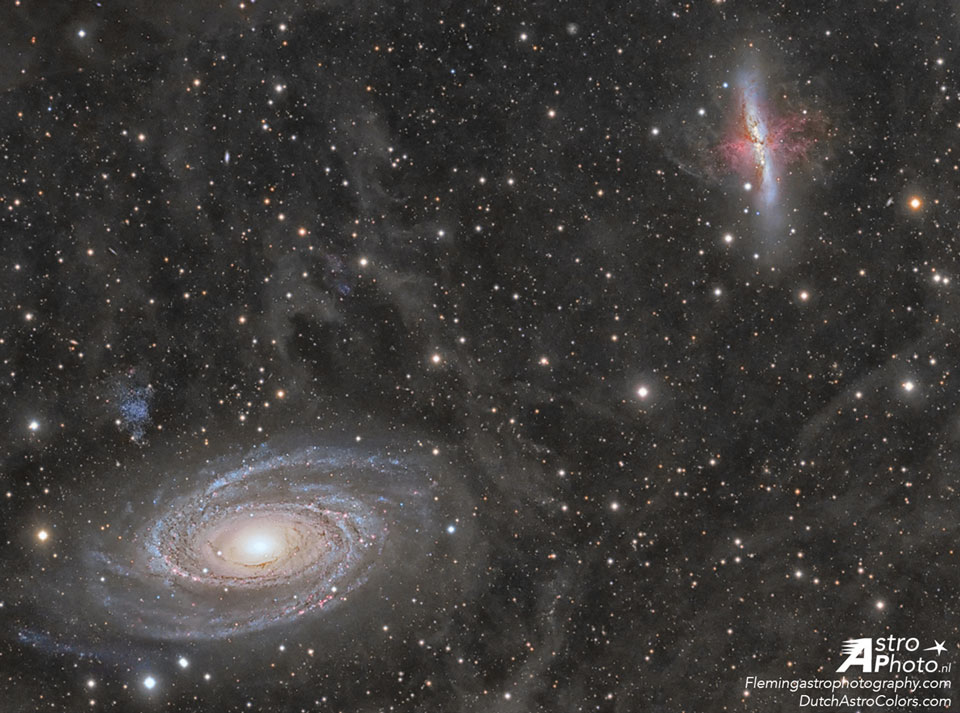 Links unten ist die prächtige Spiralgalaxie M81, rechts oben die irreguläre M82. Im Hintergrund sind viele Sterne und ein diffuser Nebel verteilt.