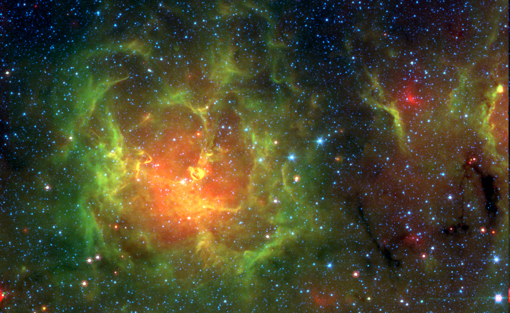 Links leuchtet ein Nebel mit grünem breitem Wolkenrand und einem rot-gelben Inneren, im Hintergrund sind Sterneverteilt.