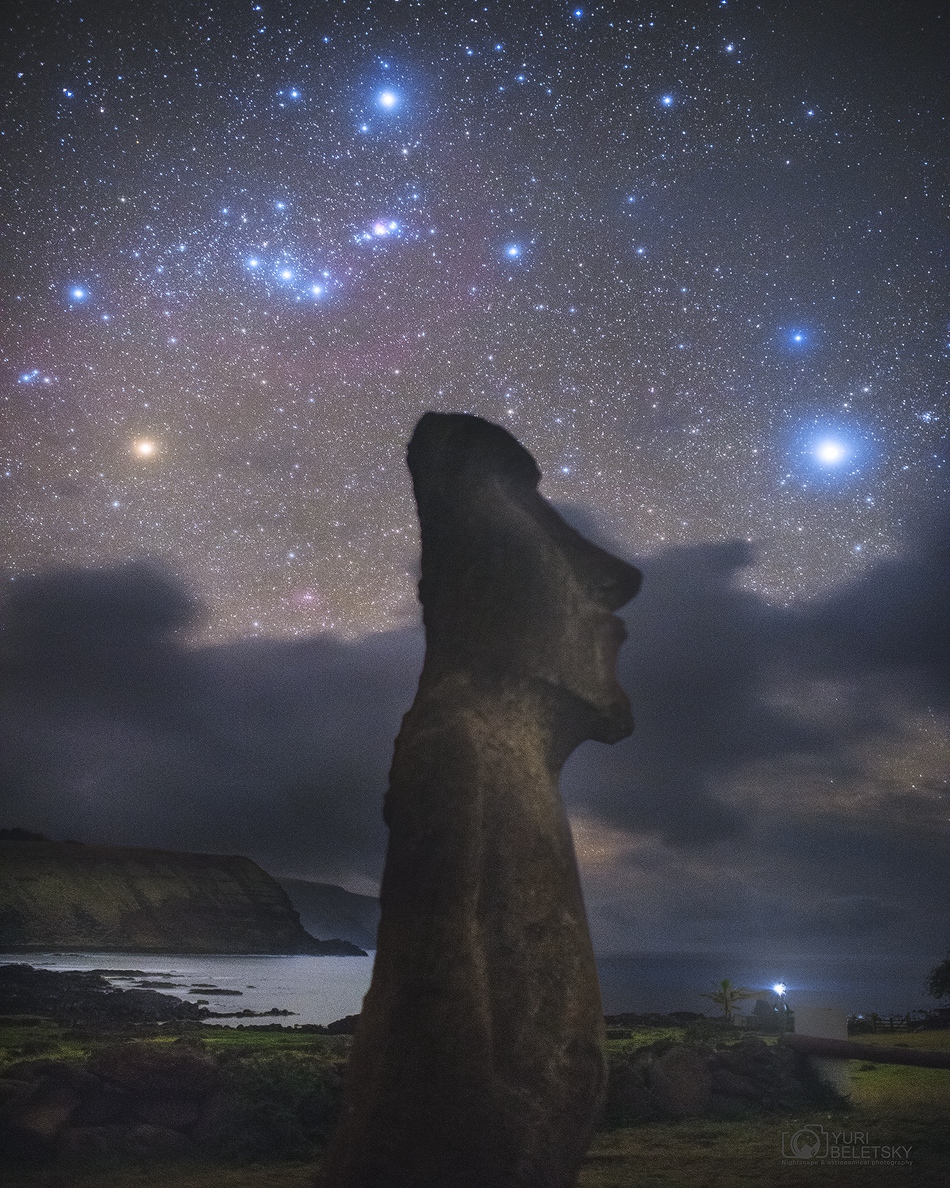 Ein urzeitlicher Moai auf der Osterinsel mustert den gleißenden Stern Sirius. Über ihm leuchten die Sternbilder Orion und Hase (Lepus).