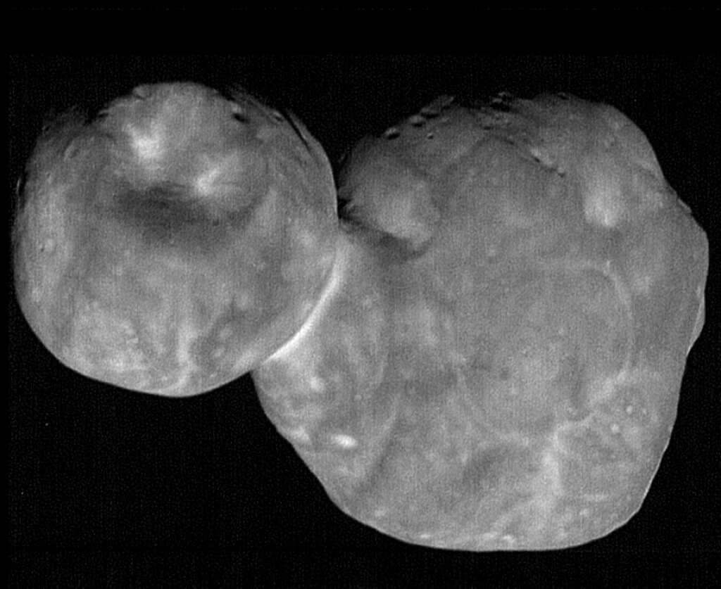 Das schwarzweiße Bild zeigt einen zweilappigen Körper vor schwarzem Hintergrund, der linke Lappen ist eine kleinere Kugel mit einem Krater.