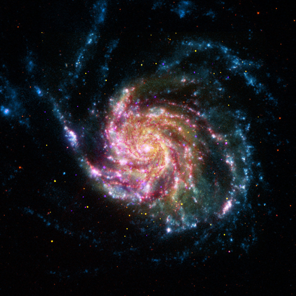 Eine lebhaft strukturierte Galaxie füllt den oberen Teil des Bildes, ihre Arme sind von rosarot leuchtenden Sternbildungsgebieten gesäumt, an den Augenrändern sind blaue Sternhaufen.