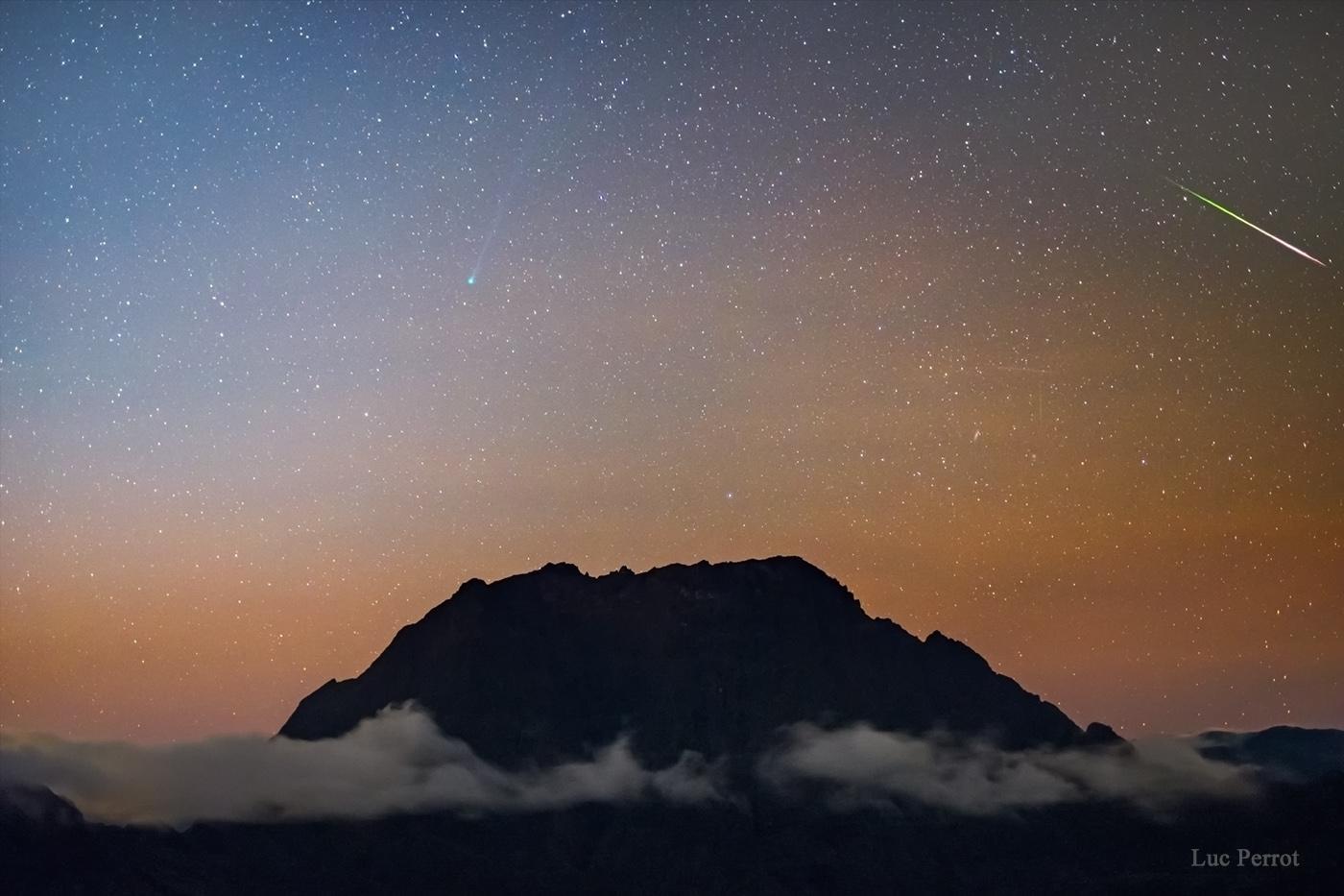 Der Meteorstrom der Eta-Aquariiden des Kometen Halley und Komet SWAN über den Gipfeln der Insel Reunion.