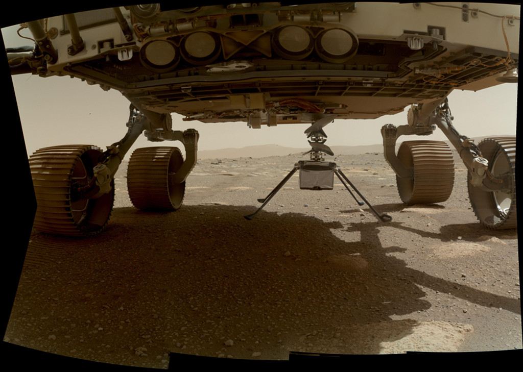 Der Mars-Hubschrauber Ingenuity hängt unter dem Rumpf des Rovers Persevrance wenige Zentimeter über dem Boden.