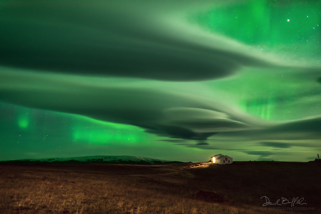 Polarlicht und Lenticularis über einem malerischen Leuchtturm bei Dyrhólaey auf Island.