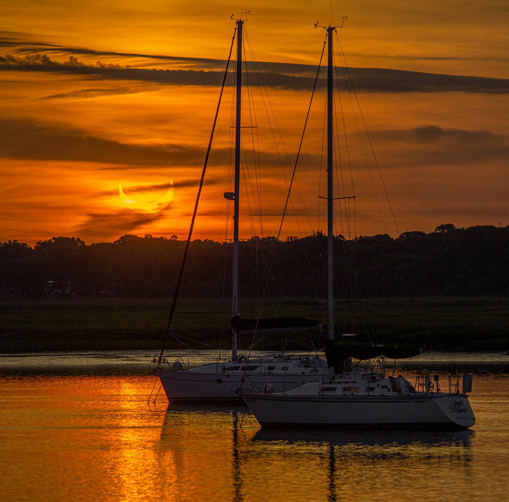 Partielle Sonnenfinsternis bei Sonnenaufgang am 10. Juni bei einem Fischersteg in Stratford (Connecticut, Nordosten der USA).