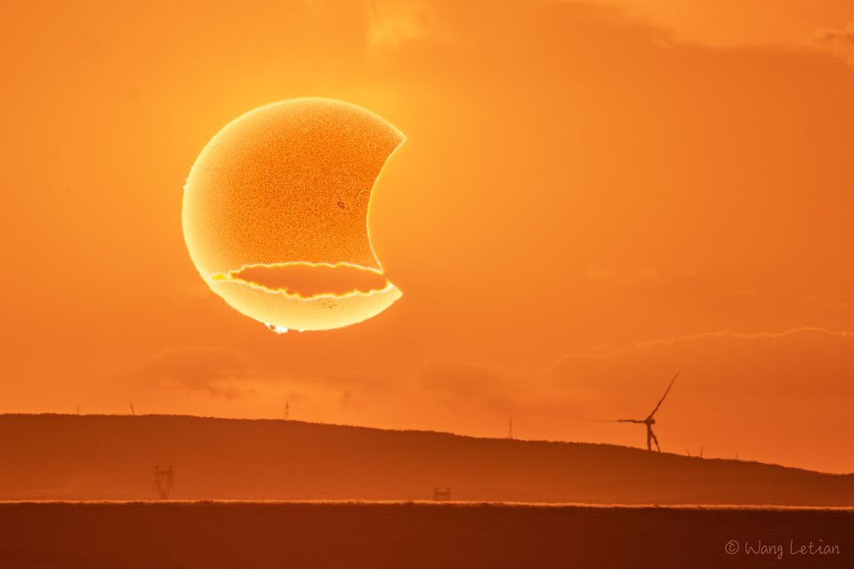 Dieses fantastische Bild vom Sonnenuntergang in Xilin Gol in der Inneren Mongolei in China zeigt Sonne und Mond bei der partiellen Sonnenfinsternis.