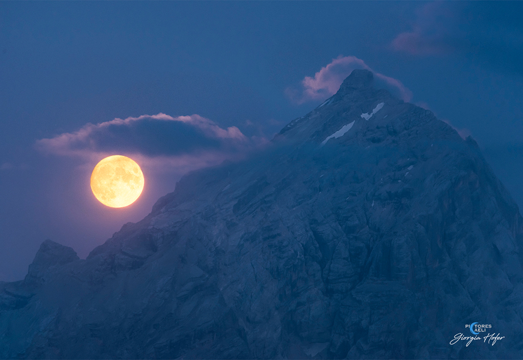 Blauer Vollmondaufgang über den italienischen Alpen von Cortina d’Ampezzo in Italien.