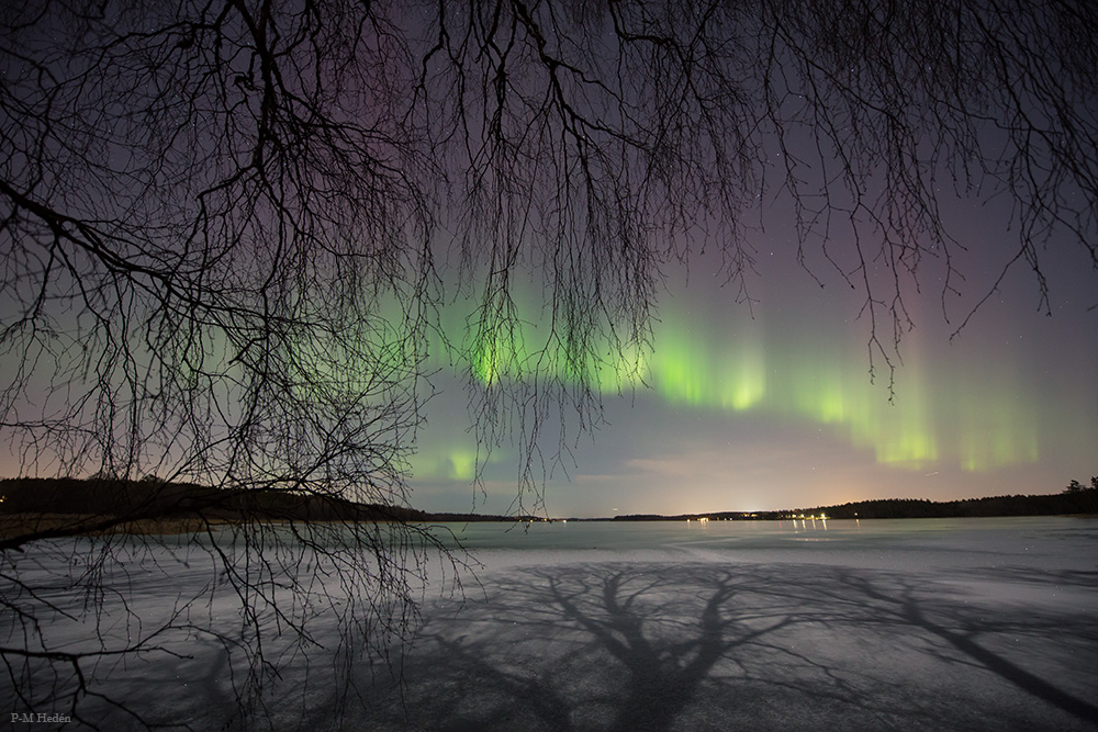 Polarlicht und Mondlicht über einem zugefrorenen See in der Nähe von Stockholm in Schweden.